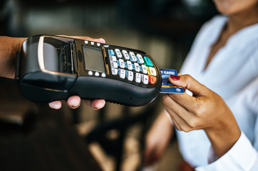 A close-up of a customer inserting a credit card into a payment terminal, illustrating secure transactions through BigCommerce Payment Gateways.